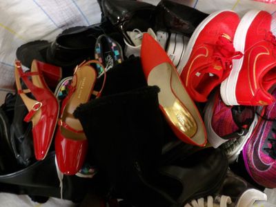 a pile of shoes and shoes that are on a bed