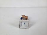 miniature figurine of a dog sitting on top of a glass block