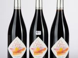 trois bouteilles de vin posées l'une à côté de l'autre sur une table