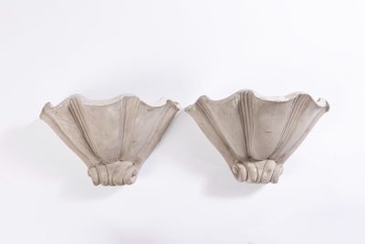 une paire d'appliques en forme de coquillages sur un mur blanc