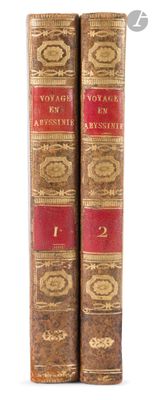 two old books sitting on top of each other on a white surface