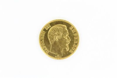 gros plan d'une pièce d'or sur une surface blanche