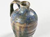a blue and green vase sitting on a white surface
