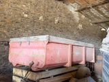 a pink dump truck sitting inside of an old barn