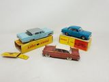 three toy cars are sitting in a box on a white surface