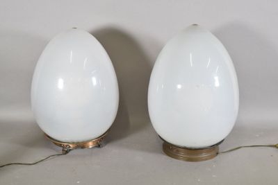une paire de lampes blanches en forme d'œuf avec des pieds en laiton, sur fond blanc