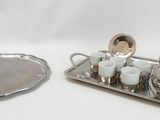 a silver tray with a silver tea set and a silver tray with cups and saucers on it