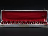a silver and red box with a pair of scissors in it