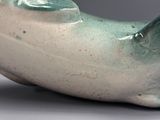 un vase vert et blanc orné d'un poisson