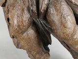 statue of a man sitting on a tree trunk with a bird on his shoulder