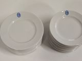 Plusieurs assiettes blanches sont empilées les unes sur les autres sur une table