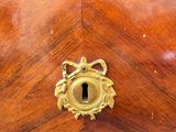 a wooden chest of drawers with a keyhole on it