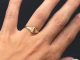 a woman ' s hand with a gold ring on it ' s finger