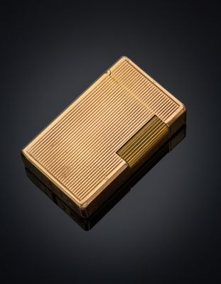a gold cigarette case sitting on top of a black surface