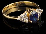 une bague en or sertie d'un saphir et de diamants sur fond noir