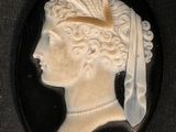 black and white cameo of a woman with a feather in her hair