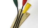 trois gobelets en plastique de couleurs différentes posés sur un morceau de bois