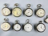 many different types of pocket watches displayed on a table