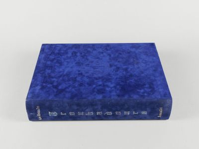 un livre bleu posé sur une surface blanche