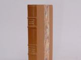 an old book sitting on top of a table next to a white wall