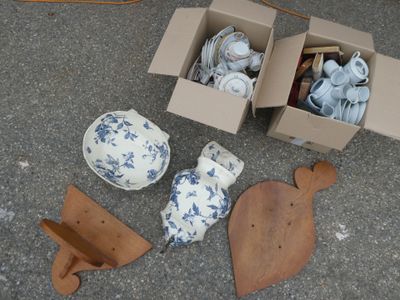 a box of tea cups and other items sitting on the ground