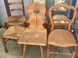 four wooden chairs sitting next to each other in a room