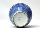 a blue and white vase sitting on a white surface