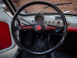 steering wheel and dashboard of a classic car with a brick wall in the background