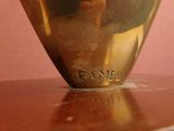 a gold vase sitting on top of a wooden table