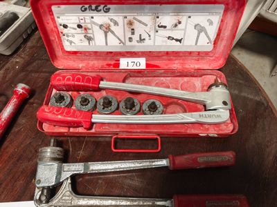 une mallette à outils rouge contenant des outils, posée sur une table
