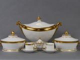 une image représentant un service à thé blanc et doré, composé de tasses et de soucoupes