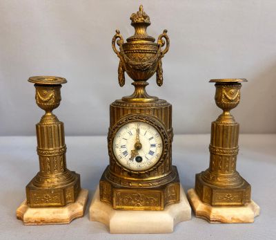 une horloge en or posée sur un socle en marbre