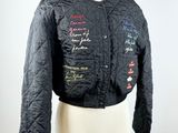 black quilted jacket with writing on it on a mannequin dummy