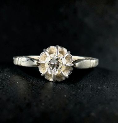 a close up of a diamond ring on a black surface