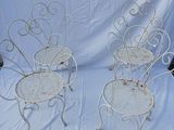 two white wrought chairs sitting on top of a white sheet