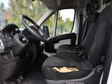 the interior of a white van with black seats and a steering wheel