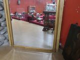 un miroir posé sur le sol devant un mur rouge