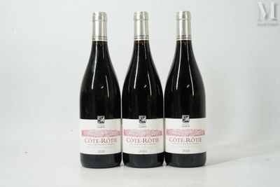 trois bouteilles de vin posées sur une table blanche
