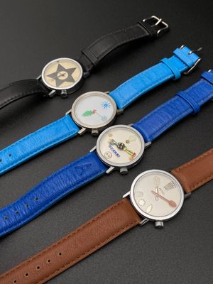 trois montres de couleurs différentes sont posées les unes à côté des autres sur une surface noire