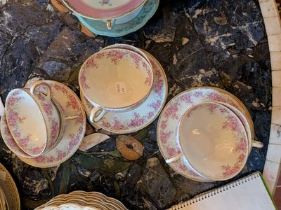 un grand nombre de tasses à thé et de soucoupes posées sur une table