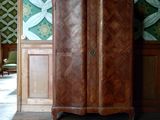 une armoire au milieu d'une pièce dont l'un des murs est tapissé