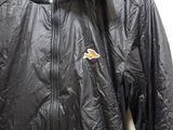 a close up of a jacket hanging on a hanger on a wall