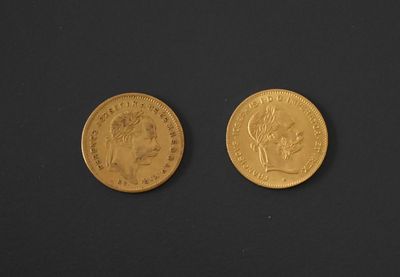 two pieces of gold coins on a black surface