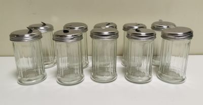 six glass jars with lids are lined up on a white surface