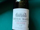 une bouteille de vin posée sur une table à côté d'un billard