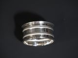 a close up of a silver ring on a black surface