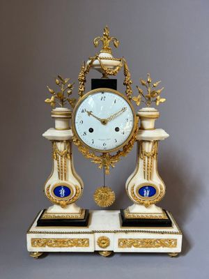 une horloge posée sur un support sur une table