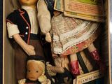 a box full of dolls that are sitting on the floor