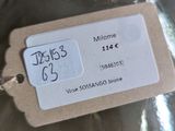 a glass bottle with a tag on it sitting on a table