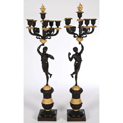 une paire de chandeliers noirs et dorés ornés de figures